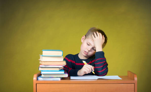 Boring School Studies. Homework. Tired little boy writing. Education concept.