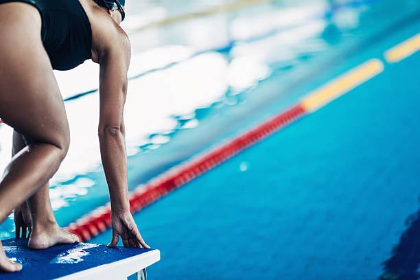 пловец на начиная блоки - women exercising swimming pool young women стоковые фото и изображения