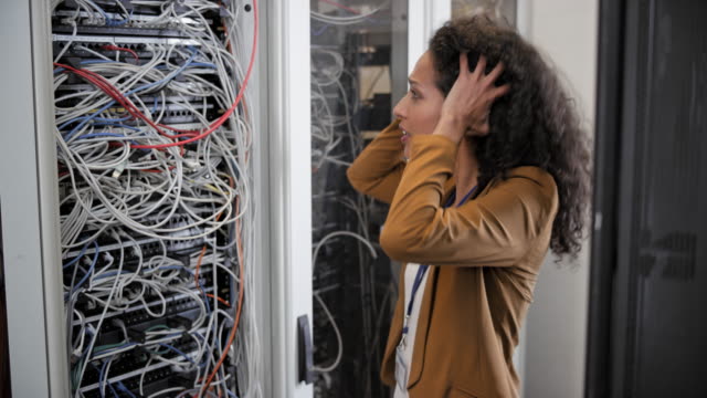 Female technician stressed about the cable mess in server rack