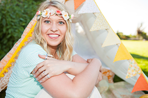 Portrait of a Young woman sitting outdoors with flowers in her hair - stock image