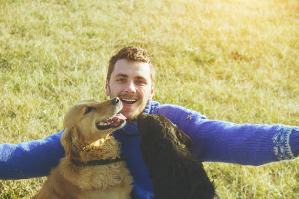 istock young man having a fun with dogs in the nature 639109608