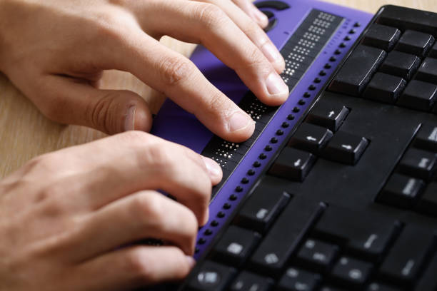 Blind person using computer with braille computer display Blind person using computer with braille computer display and a computer keyboard. Blindness aid, visual impairment, independent life concept. blindness stock pictures, royalty-free photos & images