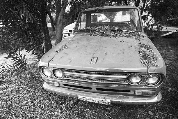 Zakynthos, Greece - August 16, 2016: closeup front view of old Datsun 1300 pickup car, black and white photo