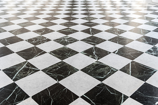 Black and white checkered marble floor with sunlight