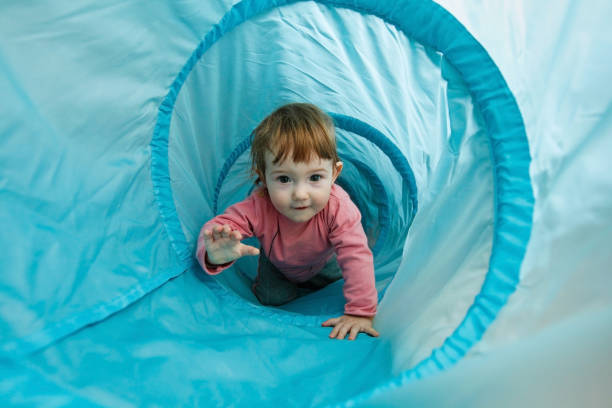 Small toddler playing in a tunnel tube Small toddler playing in a tunnel tube, crawling through it and having fun. Family fun, early education and learning through experience concept. creep stock pictures, royalty-free photos & images