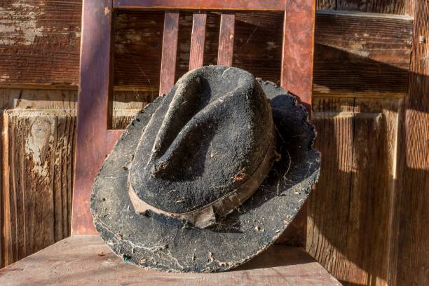 istock Battered old hat damaged by clothes moth on vintage background. 639113342