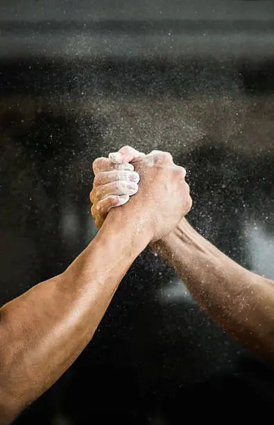 Unrecognizable strong men arm wrestling at the gym - competitive sports