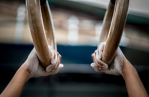 Close-up on a athlete using gymnastics rings - sports training concepts