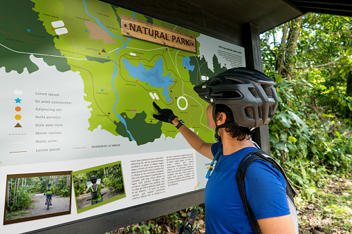 Woman traveling on a bike and looking at a map - map design is ours from scratch