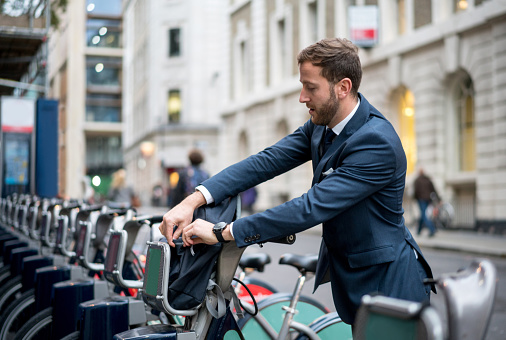 Business man renting a bike in London and looking very happy - transportation concepts