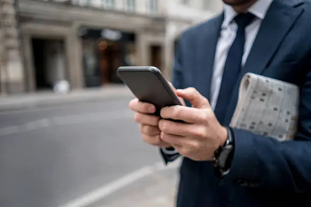 Photo of Close-up on a business man texting on the phone