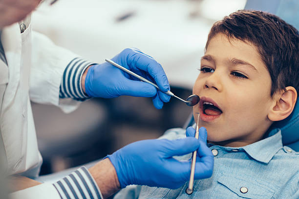 定期的な歯科検診を受けた小さな男の子 - 歯垢 ストックフォトと画像