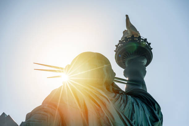 statue de la liberté au coucher du soleil - new york city government photos et images de collection