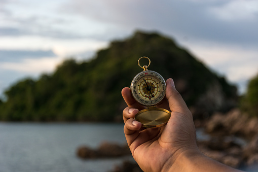 Compass in the hand on the nature background