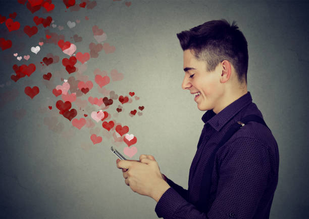 man sending love messages on mobile phone hearts flying away - speed dating bildbanksfoton och bilder