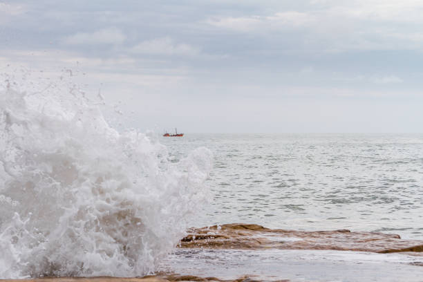 istock Fishing boat sails across the Atlantic with waves breaking off 639128552