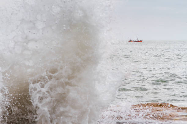 istock Fishing boat sails across the Atlantic with waves breaking off 639128668