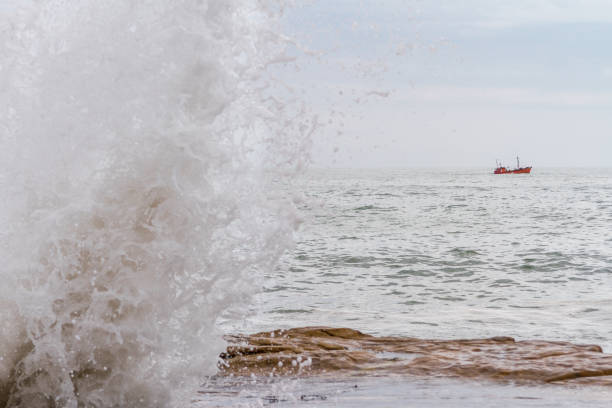 istock Fishing boat sails across the Atlantic with waves breaking off 639128766