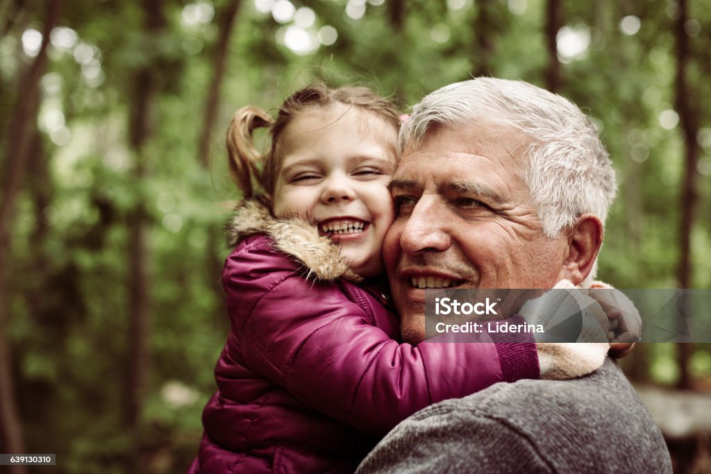 Love you so much my grandpa. Happy kid hugging grandfather in the park. Focus on grandfather. Child Stock Photo