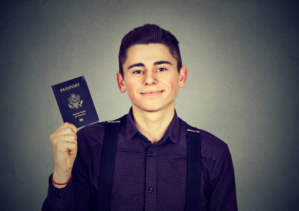istock handsome young happy man with USA passport 639133488