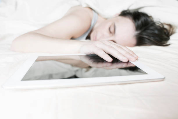 istock young woman sleeping in the bed with her digital tablet 639139184