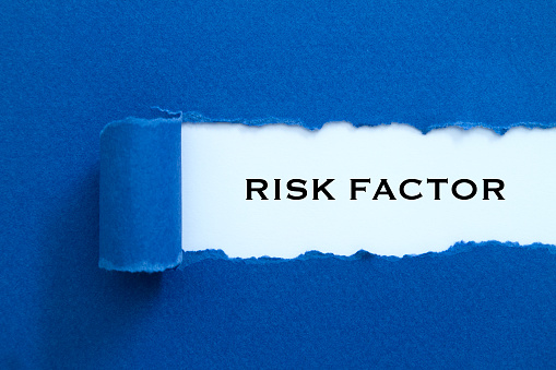 Risk Factor word written under torn paper.