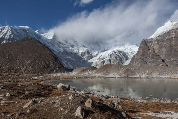 istock Grey moraine lake and snowy mountain peak covered 639144586