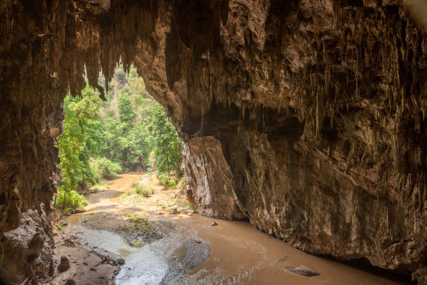 istock Enormous cave entrance with river flowing inside it. 639144992