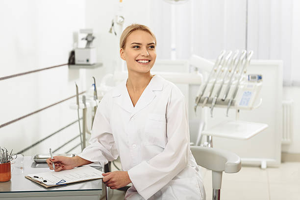 istock Cute glad stomatologist sitting in dental office 639145120