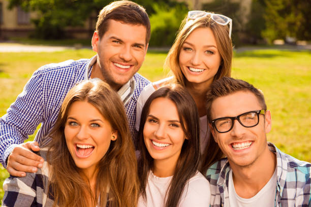 istock cheerful five friends hug and rest at sunny day 639152754