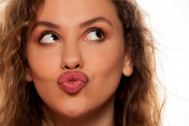 istock beautiful young woman with pursed lips 639156676