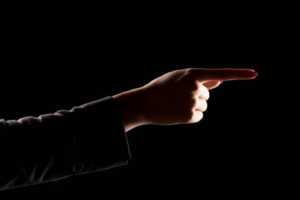 istock woman's hand on a dark background, showing direction 639156692