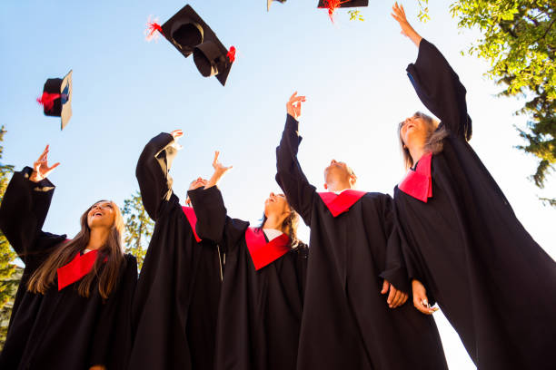 istock Successful students with congratulations together throwing up graduation hats 639156752