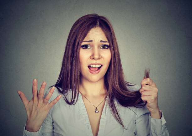 istock Frustrated woman surprised she is losing hair split ends 639162196