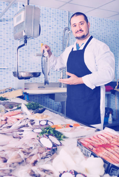 istock Seller behind scales and fish counter showing fish 639166174