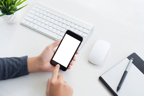 istock hand hold phone mobile and touching on workspace table 639166588