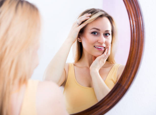 istock Young woman looking in the mirror 639168232
