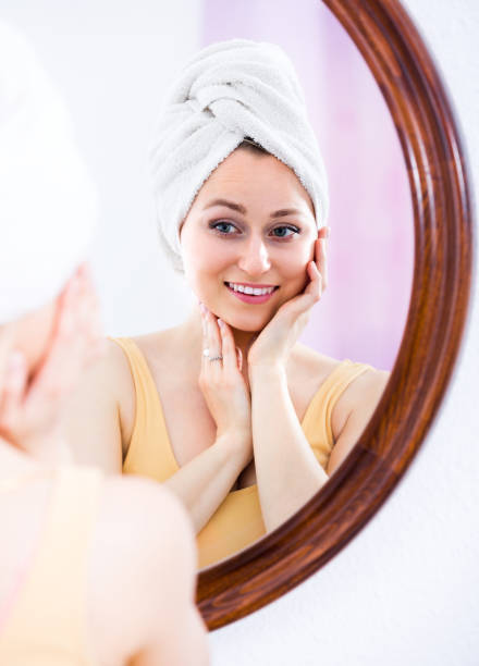 istock Young woman looking in the mirror 639168242