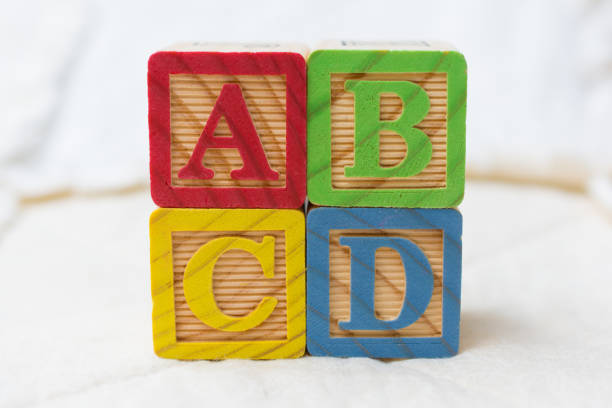 Wooden Alphabet Blocks on Quilt Spelling ABCD Stacked