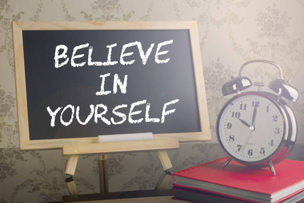 istock Believe in yourself on blackboard with flare and clock. 639174224
