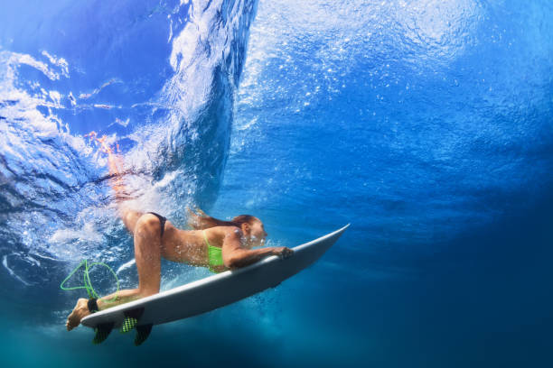 istock Active girl in bikini in dive action on surf board 639177506