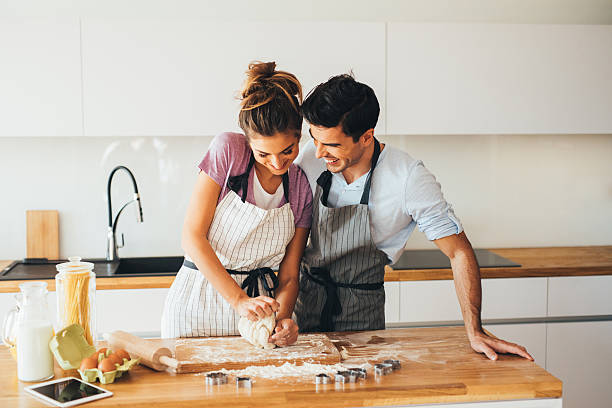 pareja haciendo galletas - baking lifestyles beautiful cookie fotografías e imágenes de stock