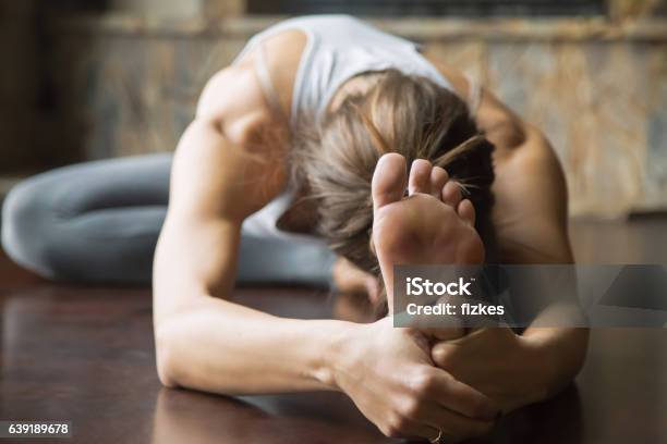 Close Up Young Woman In Janu Sirsasana Pose Home Interior Stock Photo - Download Image Now