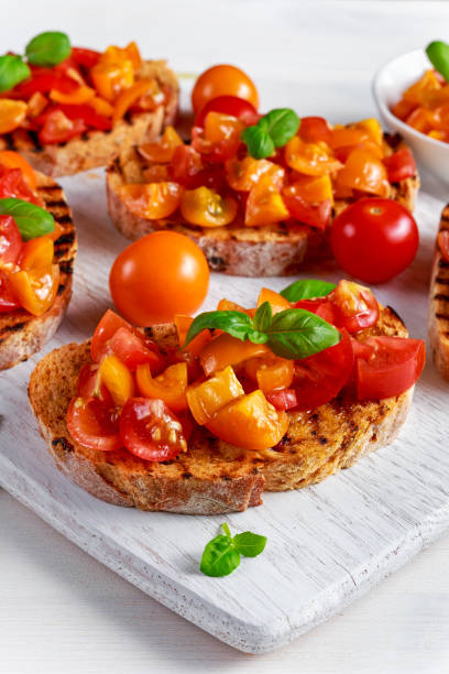 istock Tasty Traditional Tomato bruschetta with fresh basil on white board 639192150