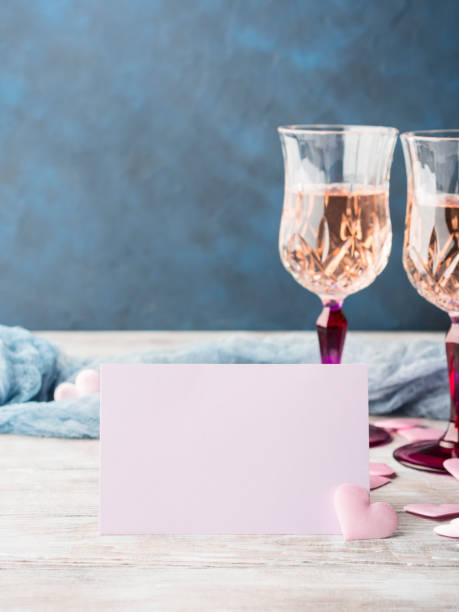 istock Two pink champagne glasses with blank paper card 639196368