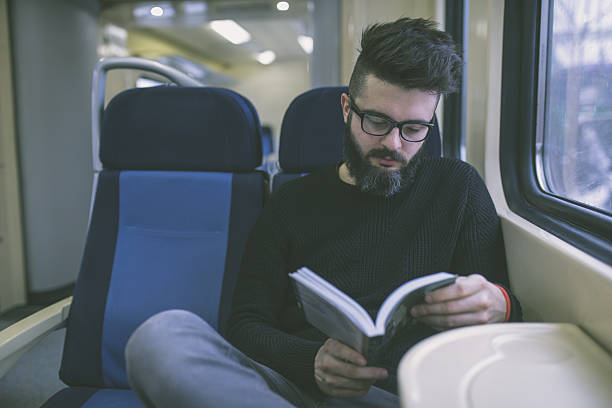 istock Young hipster reading a book on the train 639205798
