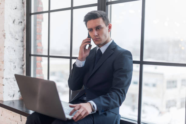istock Young man talking on his mobile phone in office. 639210350