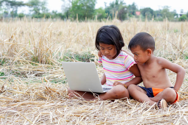 istock children looking laptop in the field. 639213090