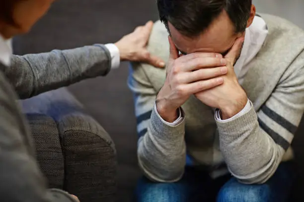 Lonely man crying during visit to psychologist