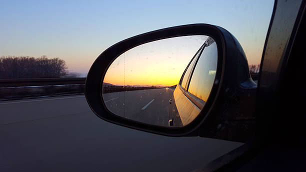 istock winter sunset side view mirror of car on highway 639218254